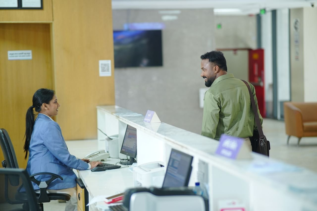 Services-03 A receptionist assists a guest at the reception desk in a modern hotel lobby in Dhaka, Bangladesh.