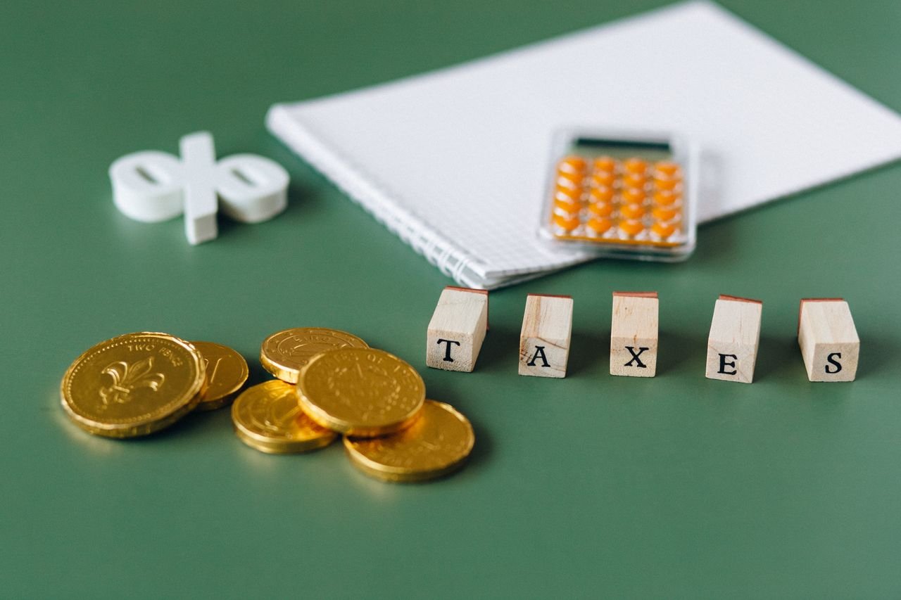 Crafting Captivating Headlines: Your awesome post title goes here Close-up of tax-related items including coins, calculator, and word 'taxes' on a green background.
