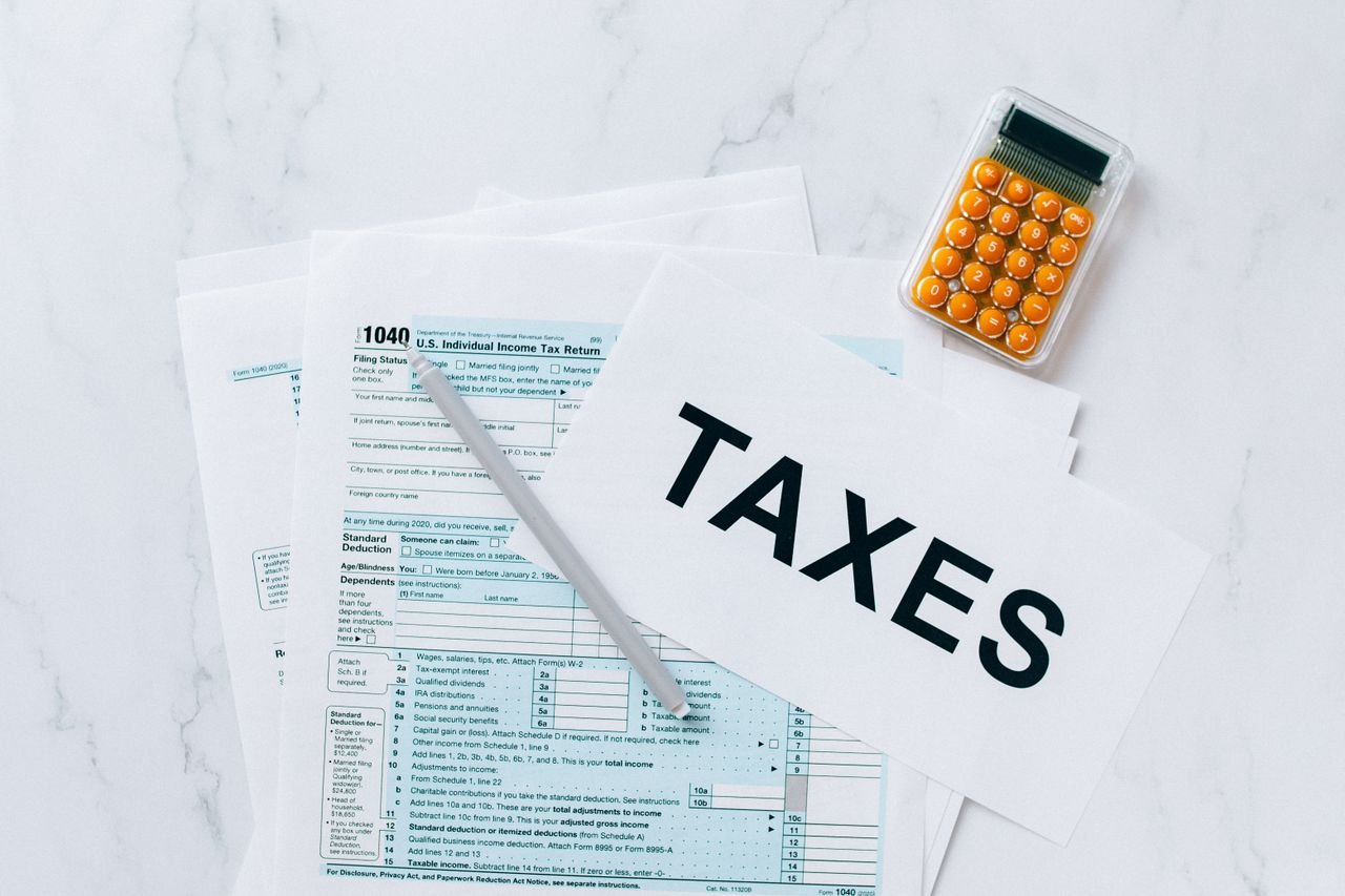 our-story Top view of tax forms, a calculator, and pen for tax preparation.